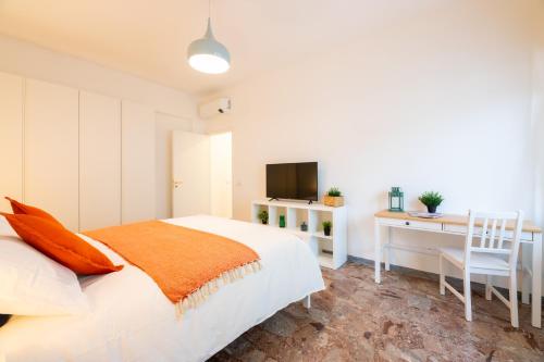 Un dormitorio con una cama, un escritorio y un televisor. en Flower Apartment, en Roma