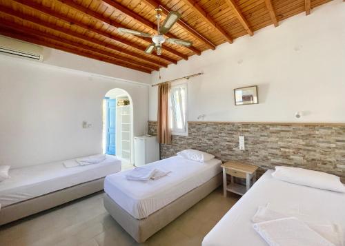 a bedroom with two beds and a brick wall at Marina In Town in Megali Ammos