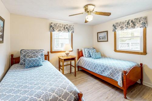 a bedroom with two beds and a ceiling fan at Spirit of the Sea in Mashpee