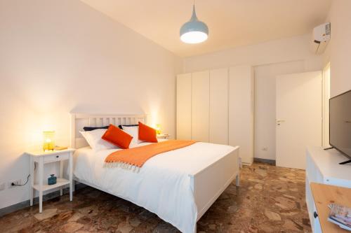 Un dormitorio con una cama blanca y un televisor de pantalla plana. en Flower Apartment, en Roma