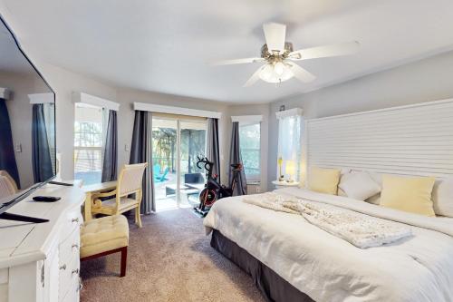 Un dormitorio con una cama grande con ventilador de techo. en The Albatross on 14th, en Cabo Coral