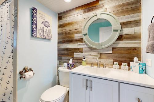 un baño con lavabo y espejo en The Albatross on 14th, en Cabo Coral