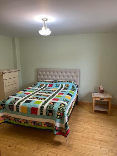 a bedroom with a bed with a quilt on it at Jagged Rocks in Twillingate