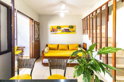 sala de estar con mesa y sofá amarillo en Apartamentos Pipa Centro, en Pipa