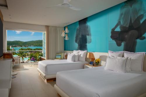 1 dormitorio con 2 camas y pared azul en Breathless Montego Bay en Montego Bay
