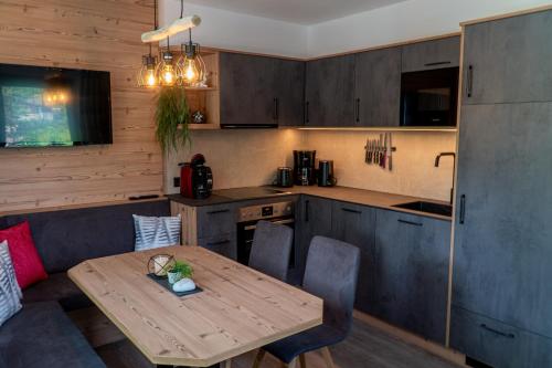 cocina con mesa de madera y comedor en Appartement Höll, en Wagrain