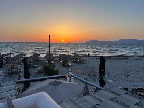 a beach with chairs and umbrellas at sunset at Majestic Sunset in Mastichari