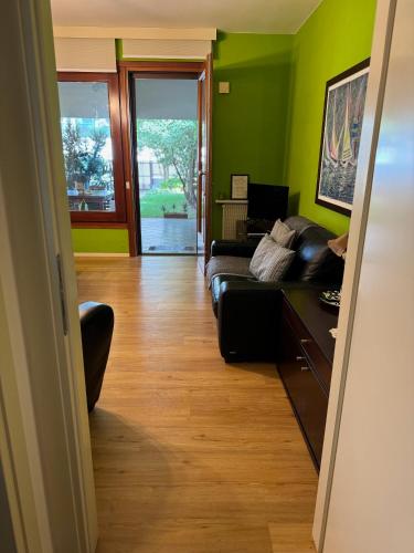 a living room with green walls and a black couch at Mi AN HOME in Paese