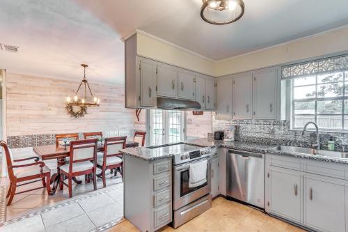 a kitchen with white cabinets and a table with chairs at Pace Family Home 1 Mi to Beach and Park! in Pace