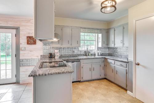 a kitchen with white cabinets and granite counter tops at Pace Family Home 1 Mi to Beach and Park! in Pace