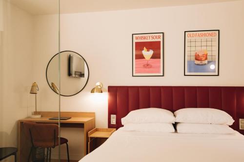 a bedroom with a bed and a desk and a mirror at H La Paloma in Barcelona