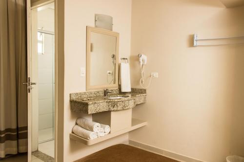 a bathroom with a sink and a mirror at Pousada Cataratas in Foz do Iguaçu