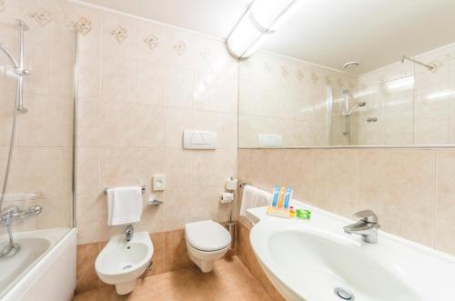 a bathroom with a tub and a toilet and a sink at Villa Fiorita in Monastier di Treviso