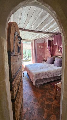 - une chambre avec un lit dans une pièce avec une arche dans l'établissement La Medievale du Luberon, à Roussillon
