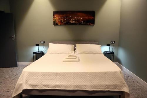 ナポリにあるGate 16 Room Napoliのベッドルーム(白い大型ベッド、ランプ2つ付)