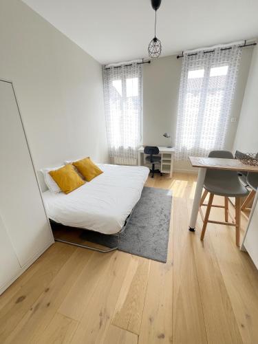 une chambre avec un lit, une table et un bureau dans l'établissement Le Petit Robert - Centre - Calme, à Toulouse