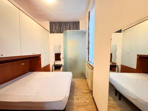 a small room with two beds and a window at Appartamenti I Liutai in Cremona