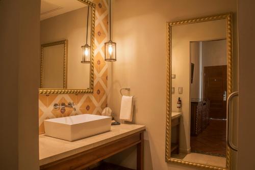 een badkamer met een wastafel en een spiegel bij Hotel Posada del Hidalgo - Centro Histórico a Balderrama Collection Hotel in El Fuerte