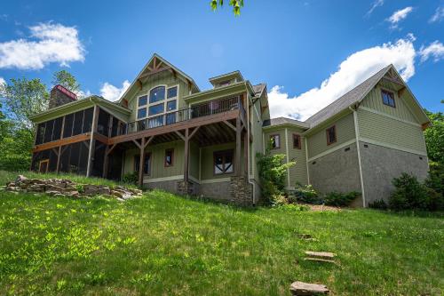 a large green house on a grassy hill at Frolly Falls in Black Mountain