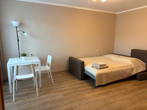 a bedroom with a bed and a table and a table at Salaspils center apartment in Salaspils