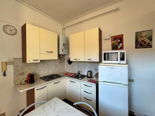 a kitchen with a white refrigerator and a microwave at Appartamenti I Liutai in Cremona