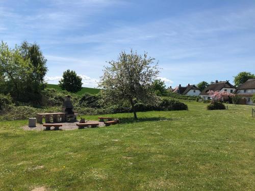 a park with picnic tables and a tree in a field at Lieblingsplatz im Reethus in Putbus