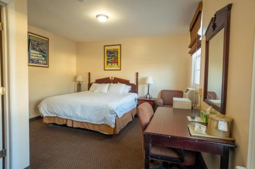 a hotel room with a bed and a desk at Watkins Motel in Watkins Glen
