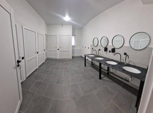 a large bathroom with three sinks and mirrors at TREND HOUSE Apartments & Hostel in Vinnytsya