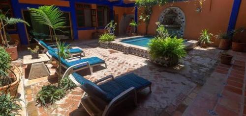 a patio with chairs and a pool in a house at Posada Las Flores in Los Ayala