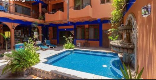 a swimming pool in front of a building at Posada Las Flores in Los Ayala