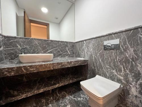 a bathroom with a sink and a toilet at Rez de jardin avec piscine privée in Casablanca