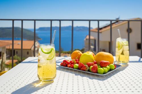 una mesa con un plato de fruta y dos vasos de zumo en Meri Suite Apart Kaş en Kas