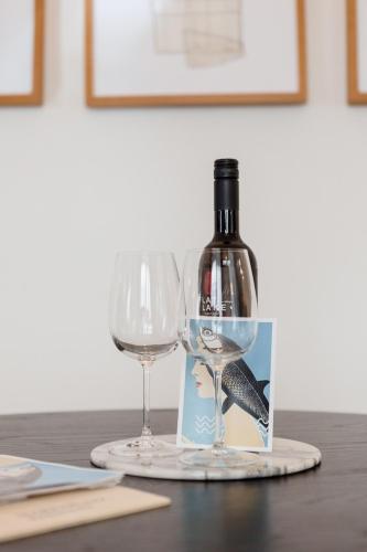 a bottle of wine and two wine glasses on a table at Marktplatz-Residenz - 110 m vom Traunsee in Gmunden