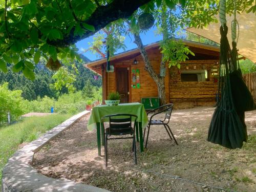 una mesa y sillas frente a una cabaña en RVilla en Pávliani