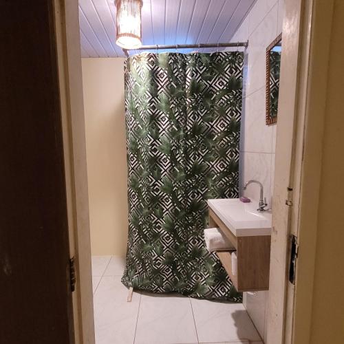 a bathroom with a shower curtain and a sink at Casa Beija-flor Pousada in Ilha de Boipeba