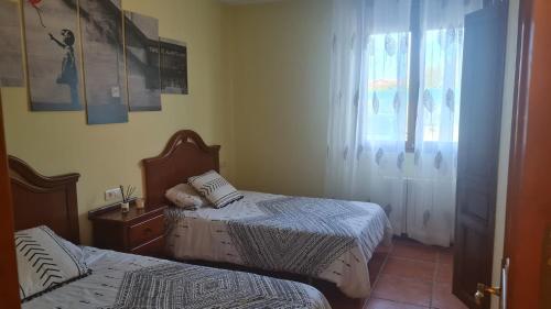a bedroom with two beds and a window at Las Brisas - planta baja independiente in Marianes