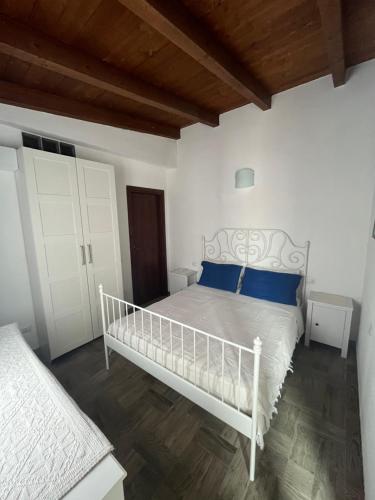 a bedroom with a white bed with blue pillows at Casa Giuli in Villasimius