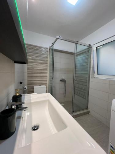 a large white bath tub in a bathroom with a shower at Melina's Apartments in Nea Kydonia