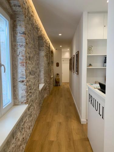 a hallway with a stone wall and a kitchen at Priuli Heritage Suites in Split
