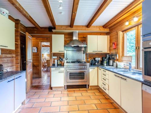 une cuisine avec des armoires blanches et une cuisinière dans l'établissement Chalet de standing à Morzine avec jacuzzi, sauna et espace jeux, à proximité des pistes - FR-1-754-2, à Morzine