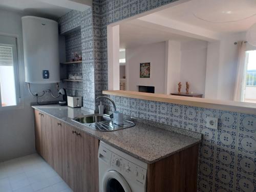 een keuken met een wastafel en een wasmachine bij Ático en Estepona, Malaga in Estepona