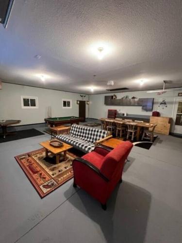a living room with a red couch and a pool table at The Clear Lake Retreat in Forest Lake