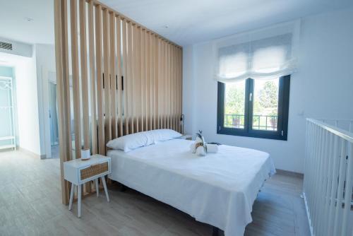a bedroom with a large white bed and a window at Villa 25 in Cabra