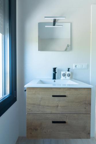 a bathroom with a white sink and a mirror at Villa 25 in Cabra