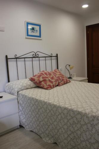 a bed with a comforter and a pillow on it at Apartamento Mar de Fora in Finisterre