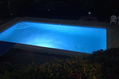 - une grande piscine bleue la nuit dans l'établissement Villa La Tartane - Les Issambres, aux Issambres