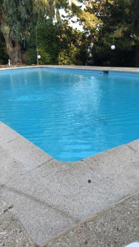 une piscine bleue avec des arbres en arrière-plan dans l'établissement Villa La Tartane - Les Issambres, aux Issambres
