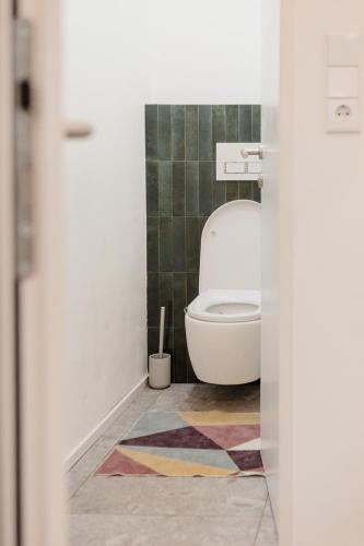 a bathroom with a toilet and a colorful rug at Marktplatz-Residenz - 110 m vom Traunsee in Gmunden
