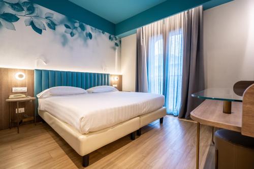 a bedroom with a large bed and a window at Hotel Regina Elena 57 & Oro Bianco SPA in Rimini