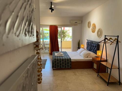 een slaapkamer met een bed en een kamer met een raam bij Oscar Villa & Studios in Alykes
